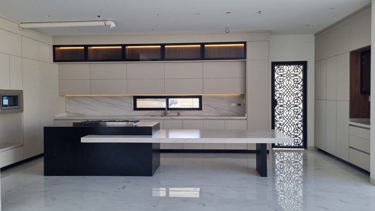 Cocina elegante Las Quintas con cubierta de granito y herrajes premium
