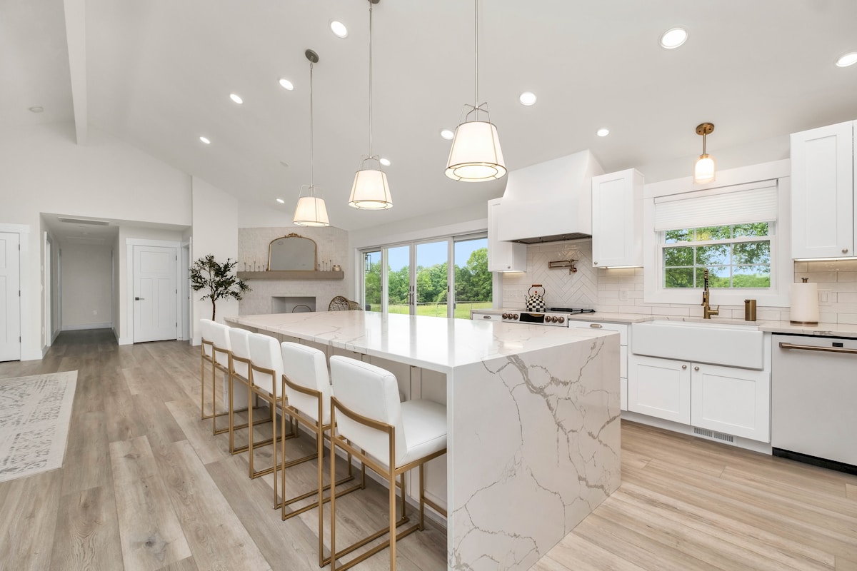 Cocina integral moderna con isla de mármol y gabinetes blancos premium